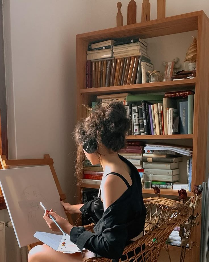 menina de fone de ouvido pintando um quadro com um fundo de livros